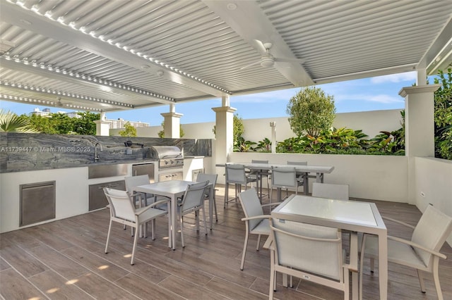 deck with a pergola, area for grilling, grilling area, a sink, and outdoor dining space