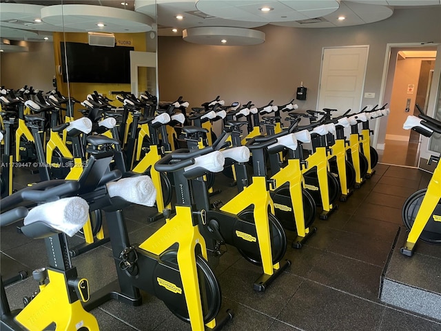 exercise room featuring a paneled ceiling, baseboards, and recessed lighting