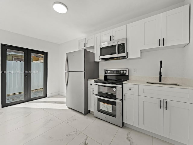 kitchen with white cabinetry, appliances with stainless steel finishes, sink, and french doors