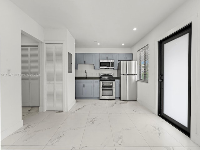 kitchen featuring gray cabinetry, sink, and stainless steel appliances