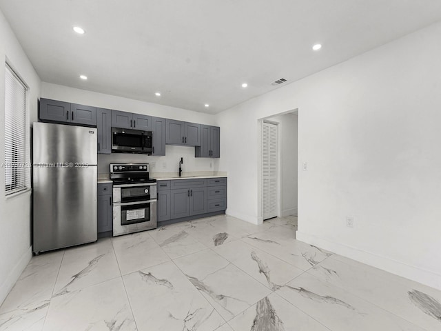 kitchen featuring sink, gray cabinets, and stainless steel appliances