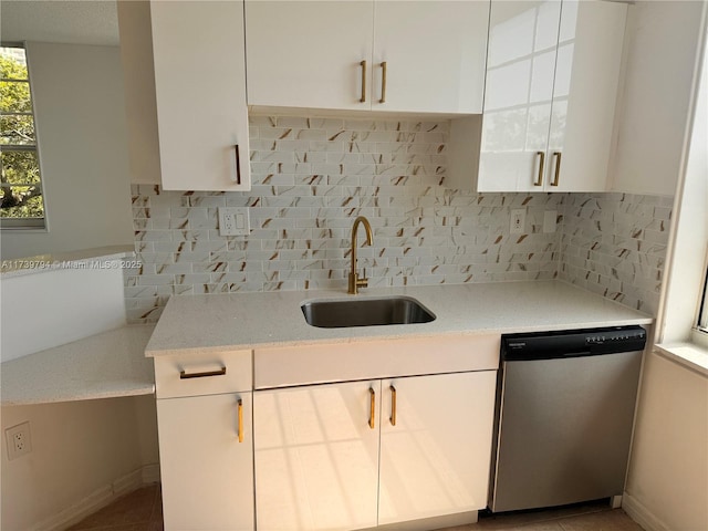 kitchen with stainless steel dishwasher, sink, decorative backsplash, and white cabinets