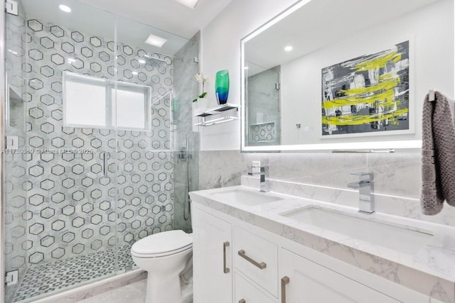 bathroom featuring vanity, toilet, a shower with shower door, and tile walls