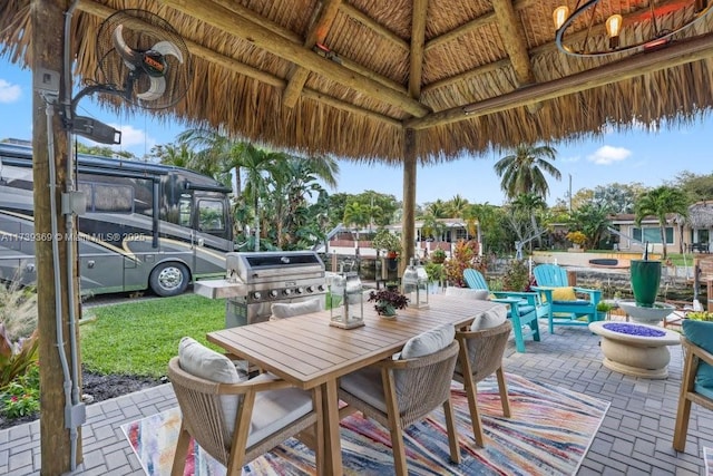 view of patio / terrace featuring a gazebo, area for grilling, and an outdoor fire pit