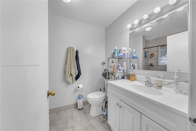 bathroom featuring vanity, toilet, and a tile shower