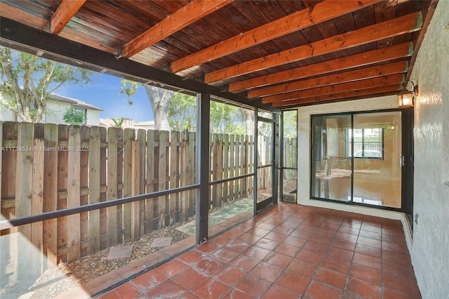 unfurnished sunroom featuring wooden ceiling and beamed ceiling