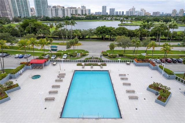 view of pool featuring a water view and a patio