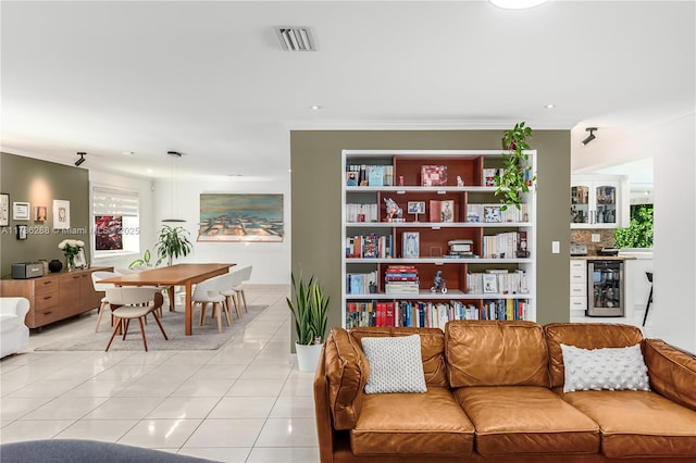 living room featuring wine cooler, light tile patterned flooring, visible vents, and crown molding