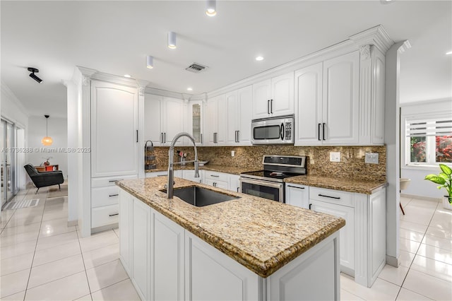 kitchen featuring light tile patterned floors, tasteful backsplash, visible vents, stainless steel appliances, and a sink