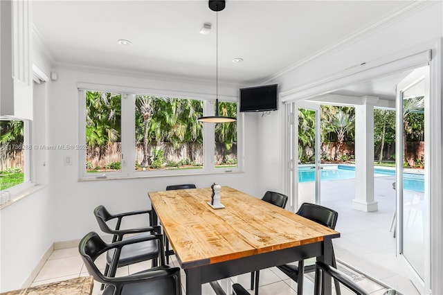 tiled dining area featuring baseboards and crown molding