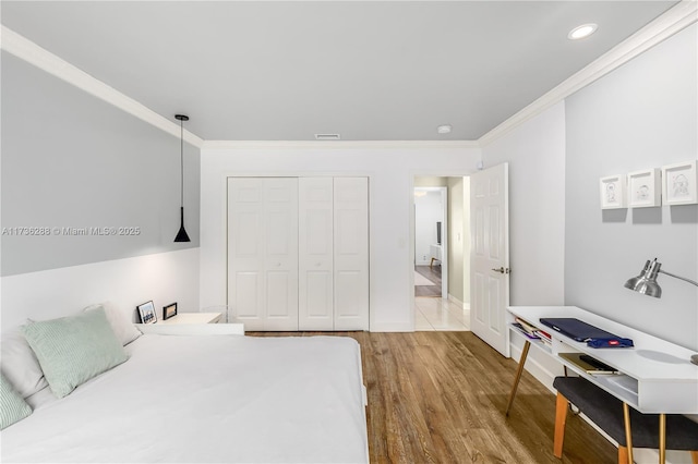 bedroom featuring recessed lighting, wood finished floors, visible vents, a closet, and crown molding