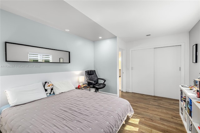 bedroom featuring a closet, wood finished floors, and recessed lighting