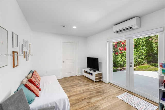 living room featuring light wood-style floors, recessed lighting, french doors, and a wall mounted AC