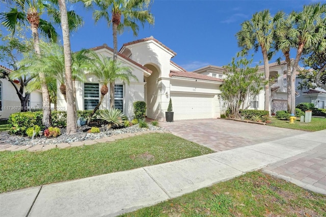 mediterranean / spanish house featuring a garage and a front yard