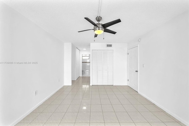 unfurnished bedroom featuring light tile patterned flooring, ceiling fan, and a textured ceiling