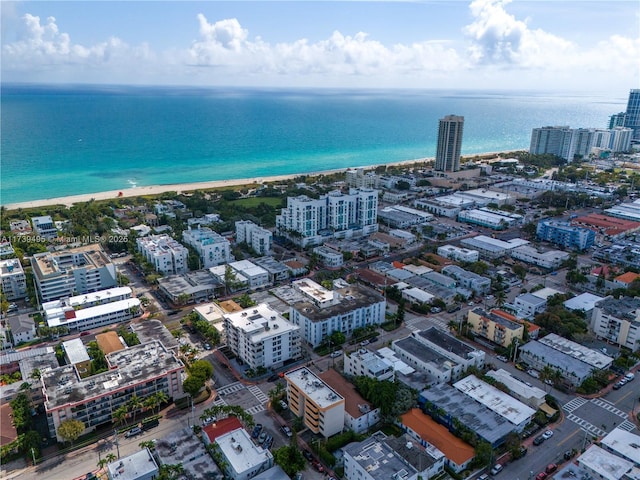 drone / aerial view featuring a water view and a view of the beach