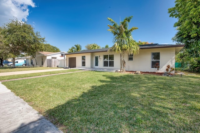 ranch-style house with concrete driveway, a front lawn, an attached garage, and stucco siding