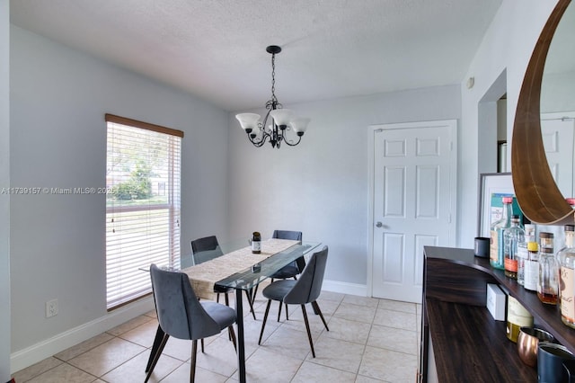 dining space with light tile patterned floors, baseboards, and an inviting chandelier