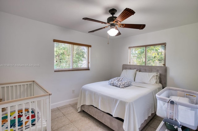 bedroom featuring light tile patterned floors, baseboards, and a ceiling fan