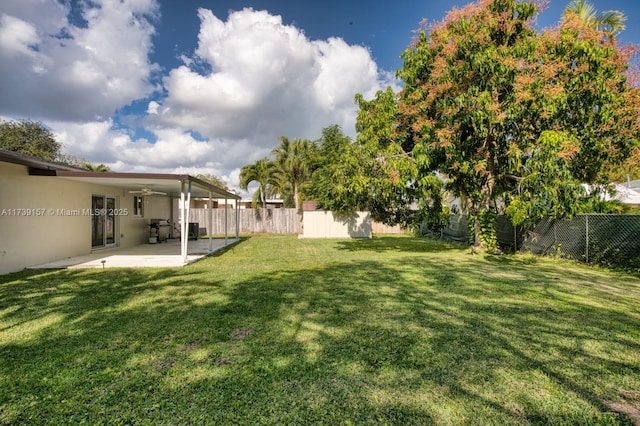 view of yard featuring ceiling fan, a patio area, and a fenced backyard