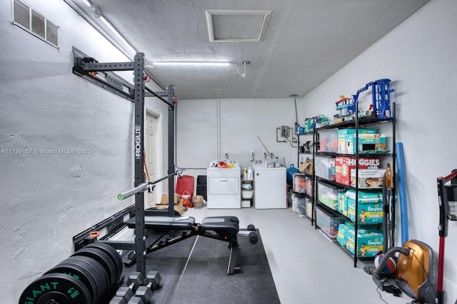 exercise room featuring attic access, visible vents, and washer and dryer