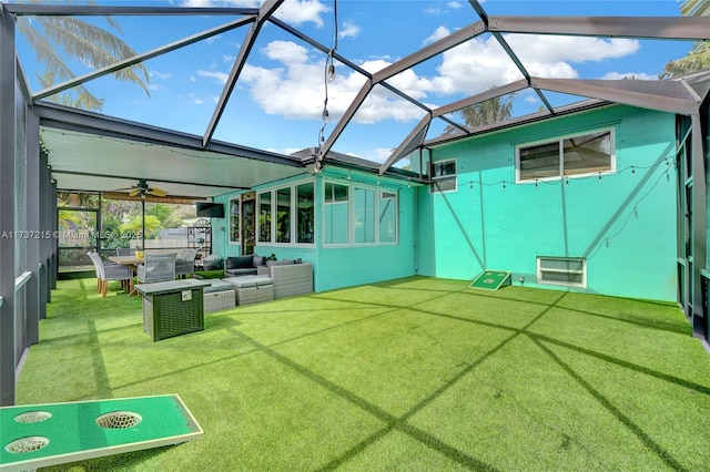 back of house with an outdoor living space, a lawn, and glass enclosure