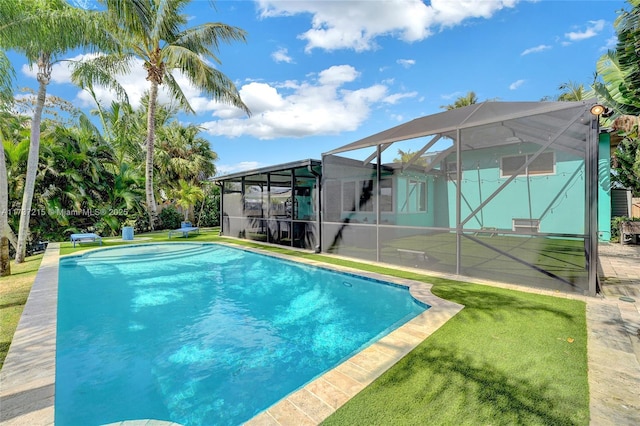 view of pool with a yard and a lanai