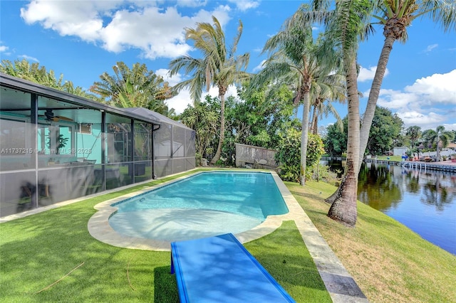 view of swimming pool with a water view, glass enclosure, and a lawn