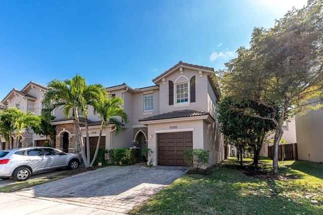 mediterranean / spanish home with a garage and a front yard