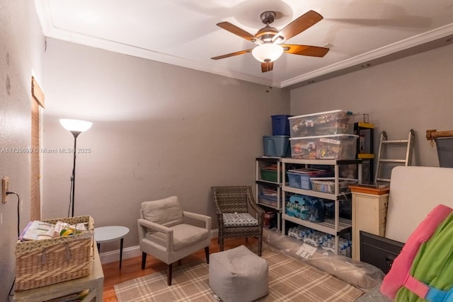 living area featuring ceiling fan, ornamental molding, and hardwood / wood-style floors