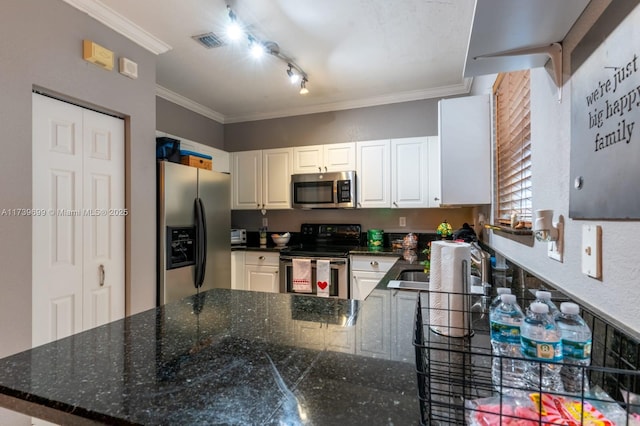 kitchen with white cabinetry, dark stone countertops, kitchen peninsula, stainless steel appliances, and crown molding