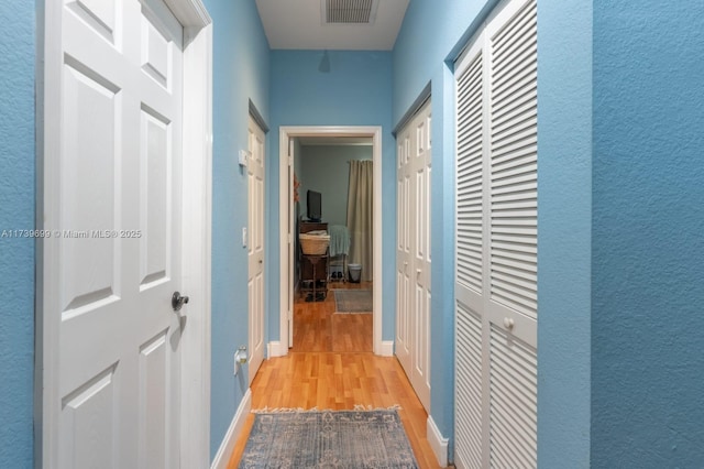 hallway with light hardwood / wood-style floors