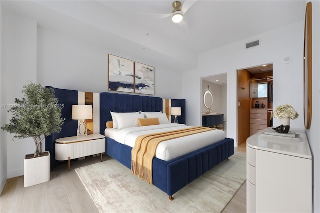 bedroom with wood-type flooring, connected bathroom, and ceiling fan