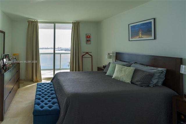 bedroom featuring floor to ceiling windows, a water view, light colored carpet, and access to exterior