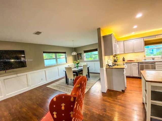 kitchen with white cabinetry, pendant lighting, dark hardwood / wood-style floors, and stainless steel dishwasher