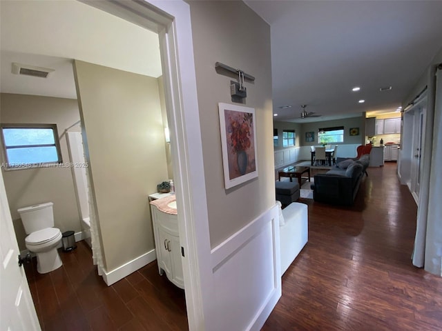 corridor featuring plenty of natural light and dark hardwood / wood-style flooring