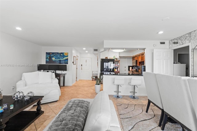 living room with light tile patterned flooring, visible vents, and recessed lighting