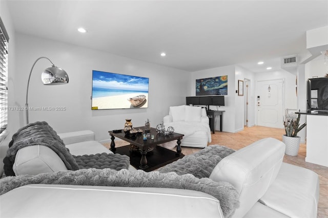 living room with light tile patterned floors, visible vents, and recessed lighting