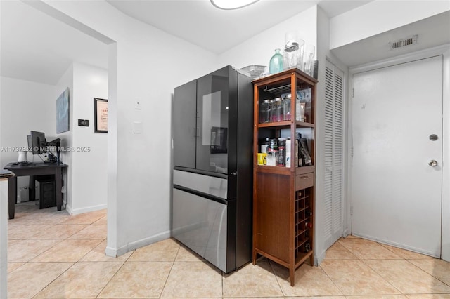 kitchen with light tile patterned floors, smart refrigerator, visible vents, and baseboards