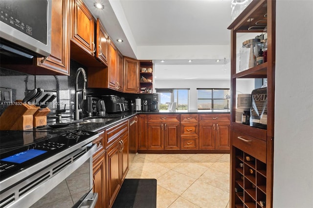 kitchen with light tile patterned flooring, stainless steel appliances, a sink, brown cabinets, and open shelves