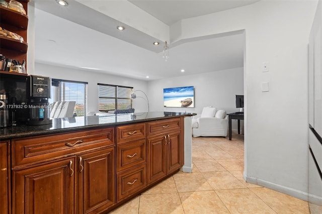 kitchen featuring light tile patterned floors, recessed lighting, brown cabinets, dark stone counters, and open shelves