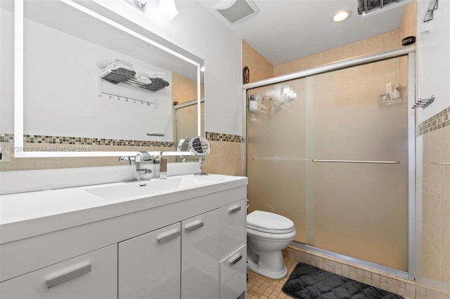 full bathroom featuring toilet, tile patterned flooring, vanity, a shower stall, and tile walls