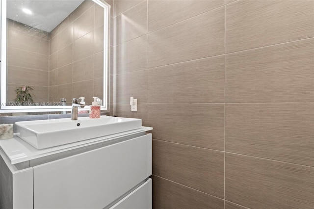 bathroom with tile walls and vanity