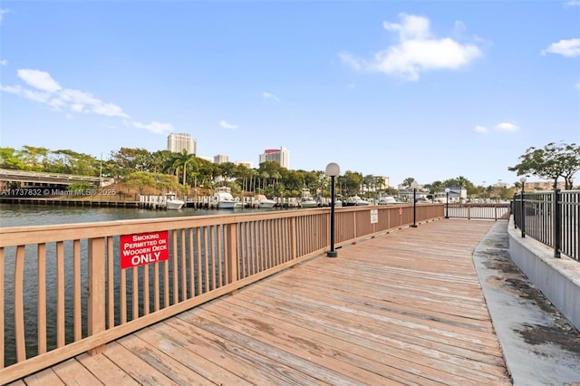 wooden terrace featuring a water view and a city view