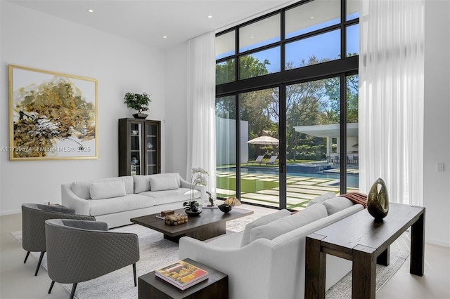 living room with a wall of windows, a healthy amount of sunlight, and a high ceiling