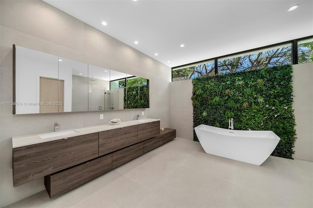 bathroom with vanity, a wall of windows, and separate shower and tub