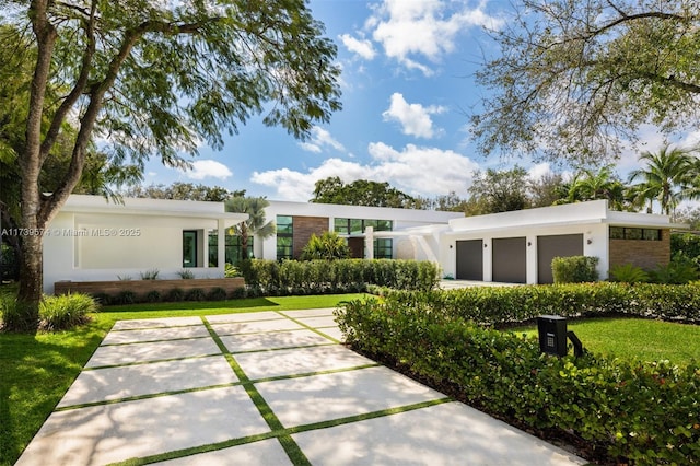 view of front of property with a garage and a front lawn