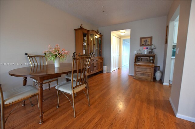 dining room with a textured ceiling and light hardwood / wood-style floors