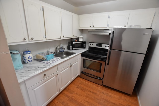 kitchen featuring stainless steel appliances, light hardwood / wood-style floors, sink, and white cabinets