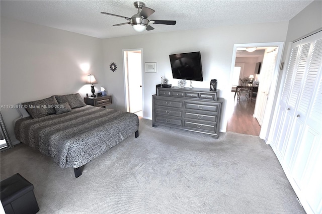 bedroom featuring ceiling fan, a closet, a textured ceiling, and carpet flooring